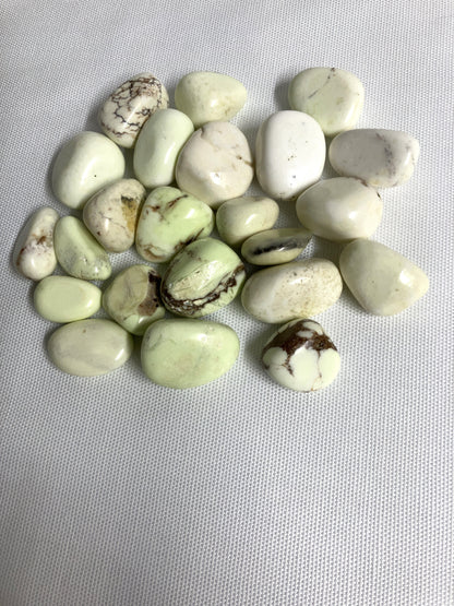 Front view of Lemon Chrysoprase Tumbled Crystals on a gray background