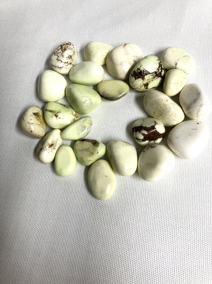Lemon Chrysoprase Tumbled Crystals in a circular pattern on a light gray background