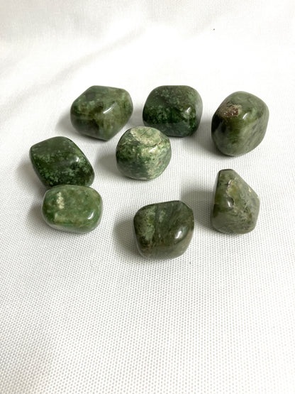 Back view of Grossularite Crystal aka Green Garnet on a white fabric background