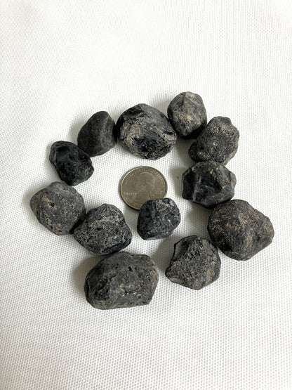 Rough Apache Tears stones on a white fabric background