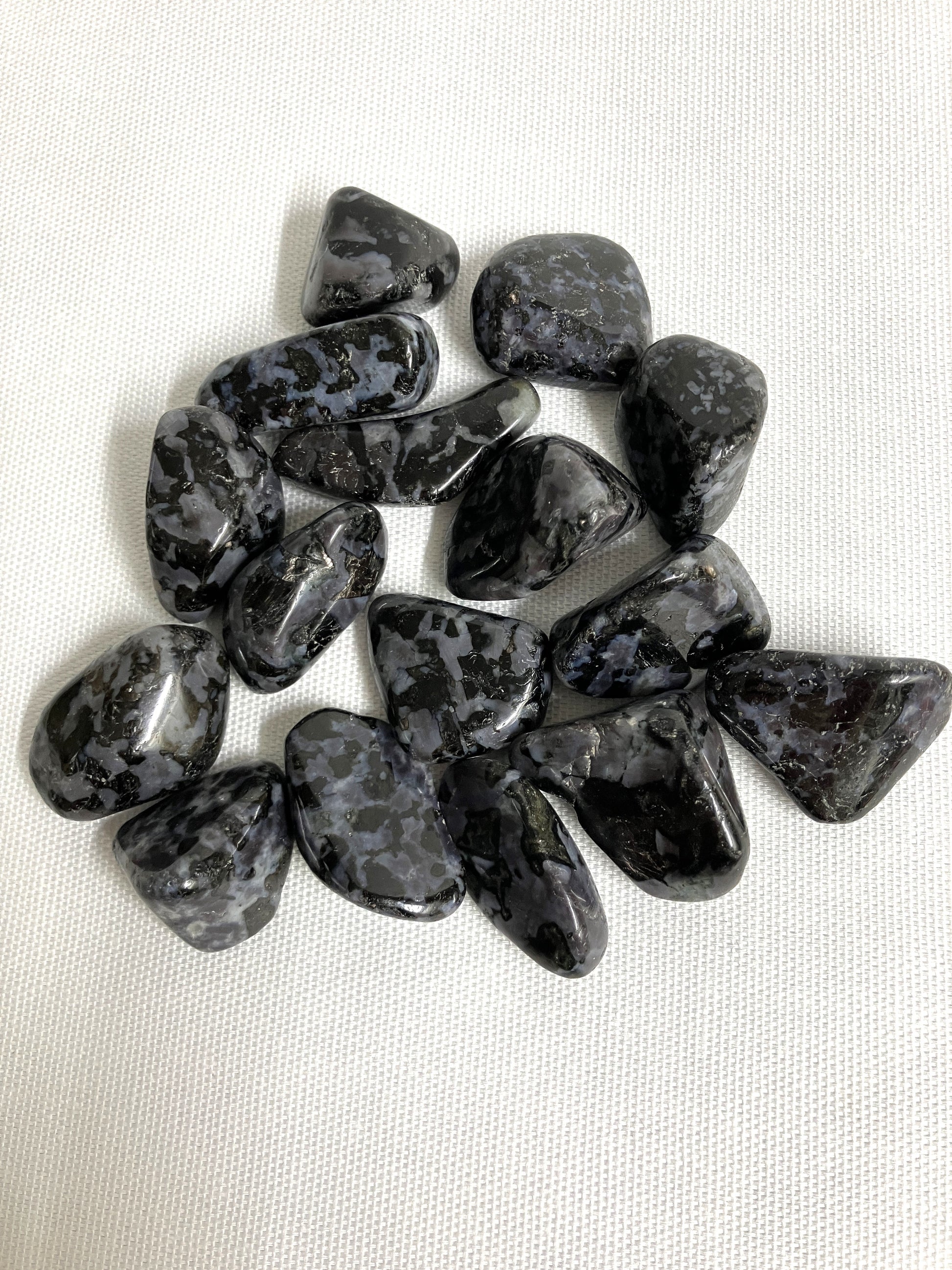 Closeup view of Indigo Gabbro Tumbled Crystals on a white background