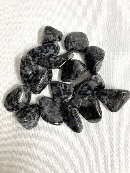 Closeup view of Indigo Gabbro Tumbled Crystals on a white background