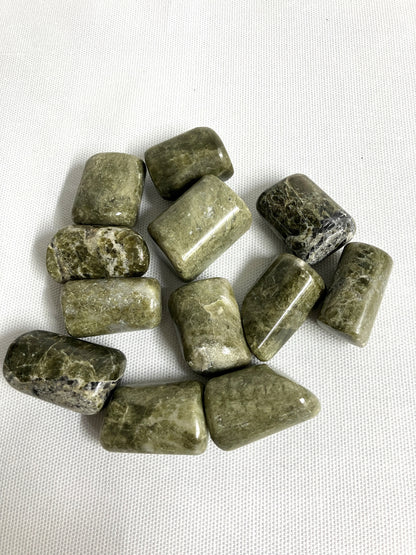 Closeup of Vesuvianite Tumbled Crystals on a white fabric background