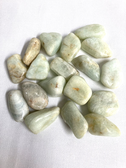 Tumbled Aquamarine Crystals on a white fabric background