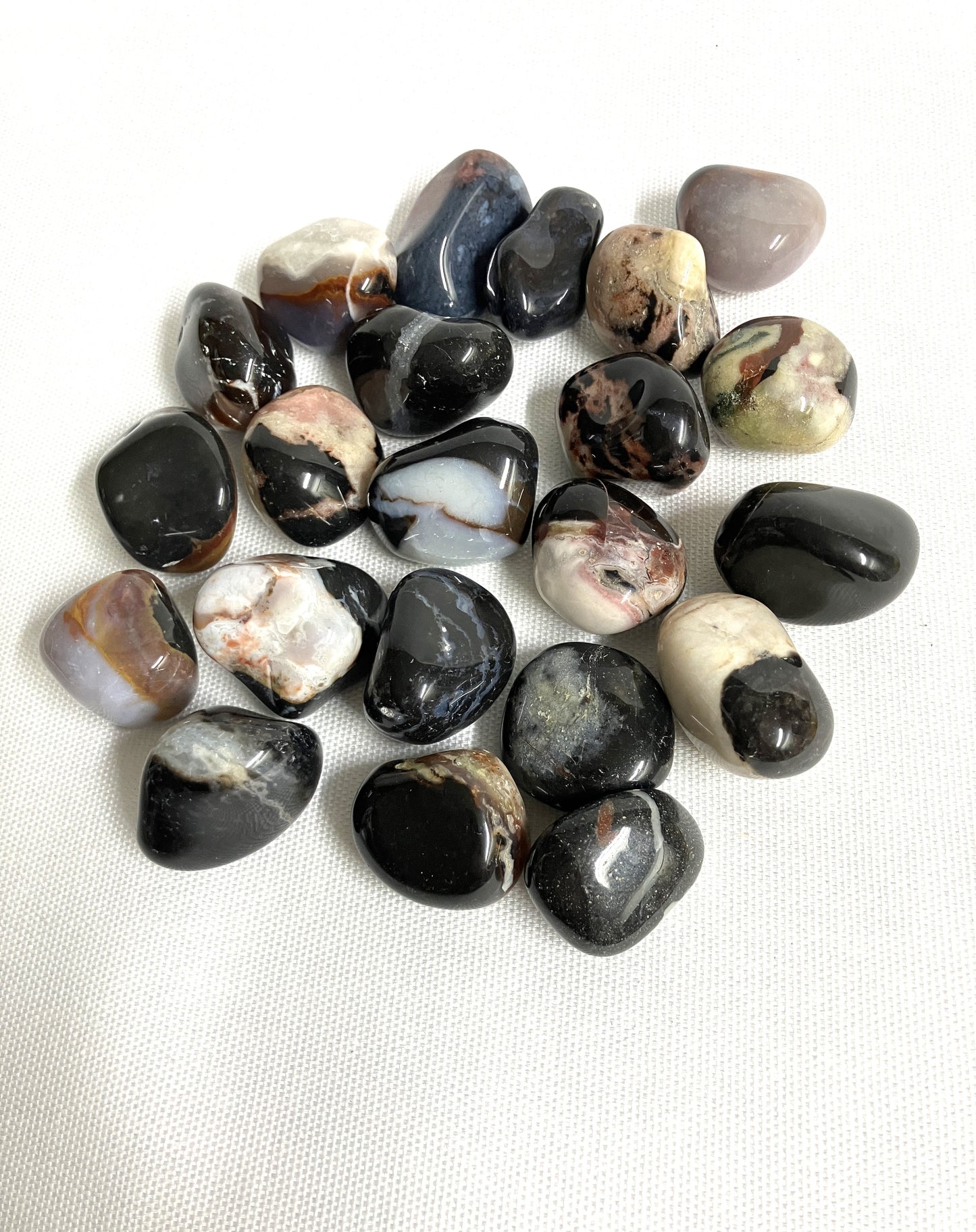 Tumbled Black Sardonyx Crystals on a white background