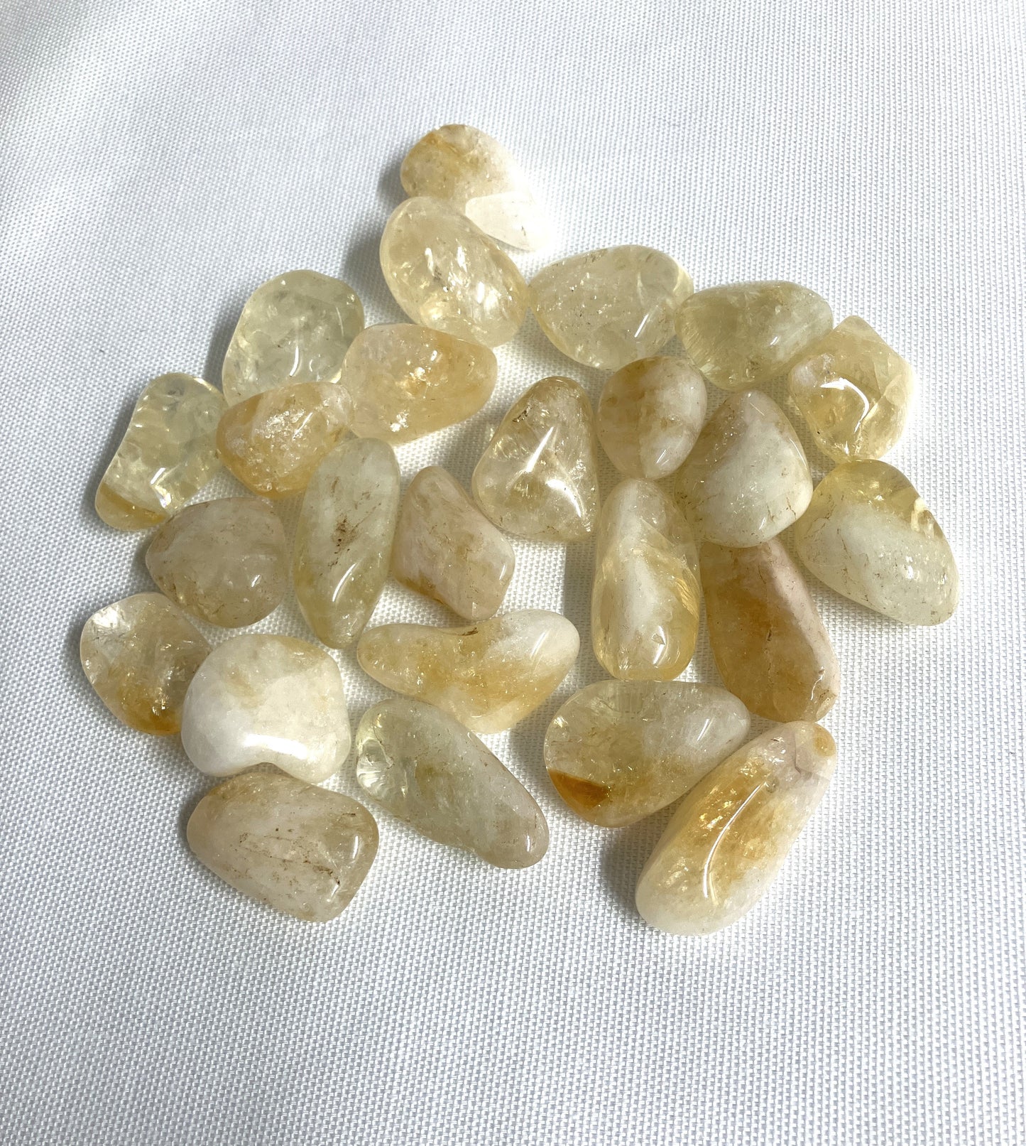 Citrine Tumbled Crystals showing front side on a white fabric background