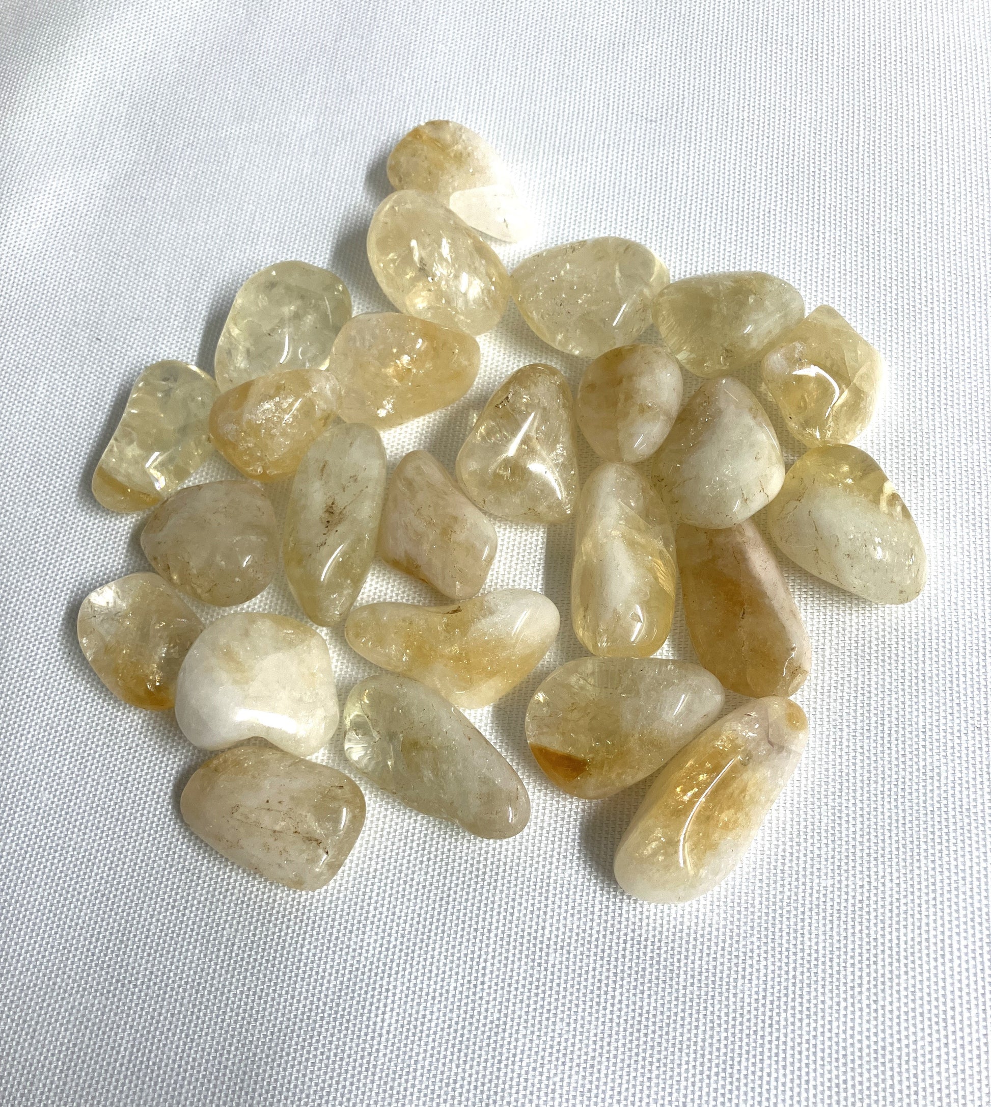 Citrine Tumbled Crystals showing front side on a white fabric background