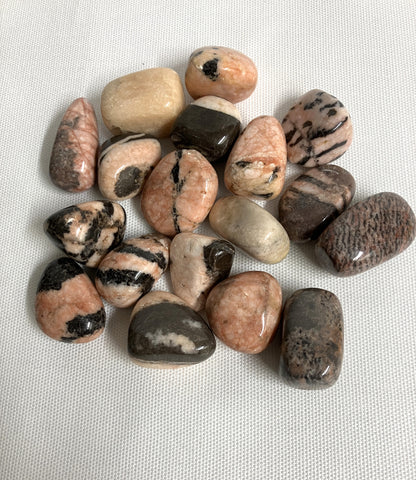 Back view of Pink Zebra Jasper Crystals showing patterns and color variants on a textured white surface