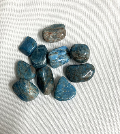 Group of Blue Apatite Crystals showing the pattern and colors  on a textured white surface