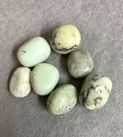Green Chrysoprase Crystals showing texture of the stone on a gray surface