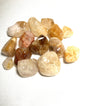Assorted tumbled Golden Healer Crystals shown on a white background