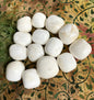 Scolecite Crystals arranged in a circular pattern on a decorative fabric background
