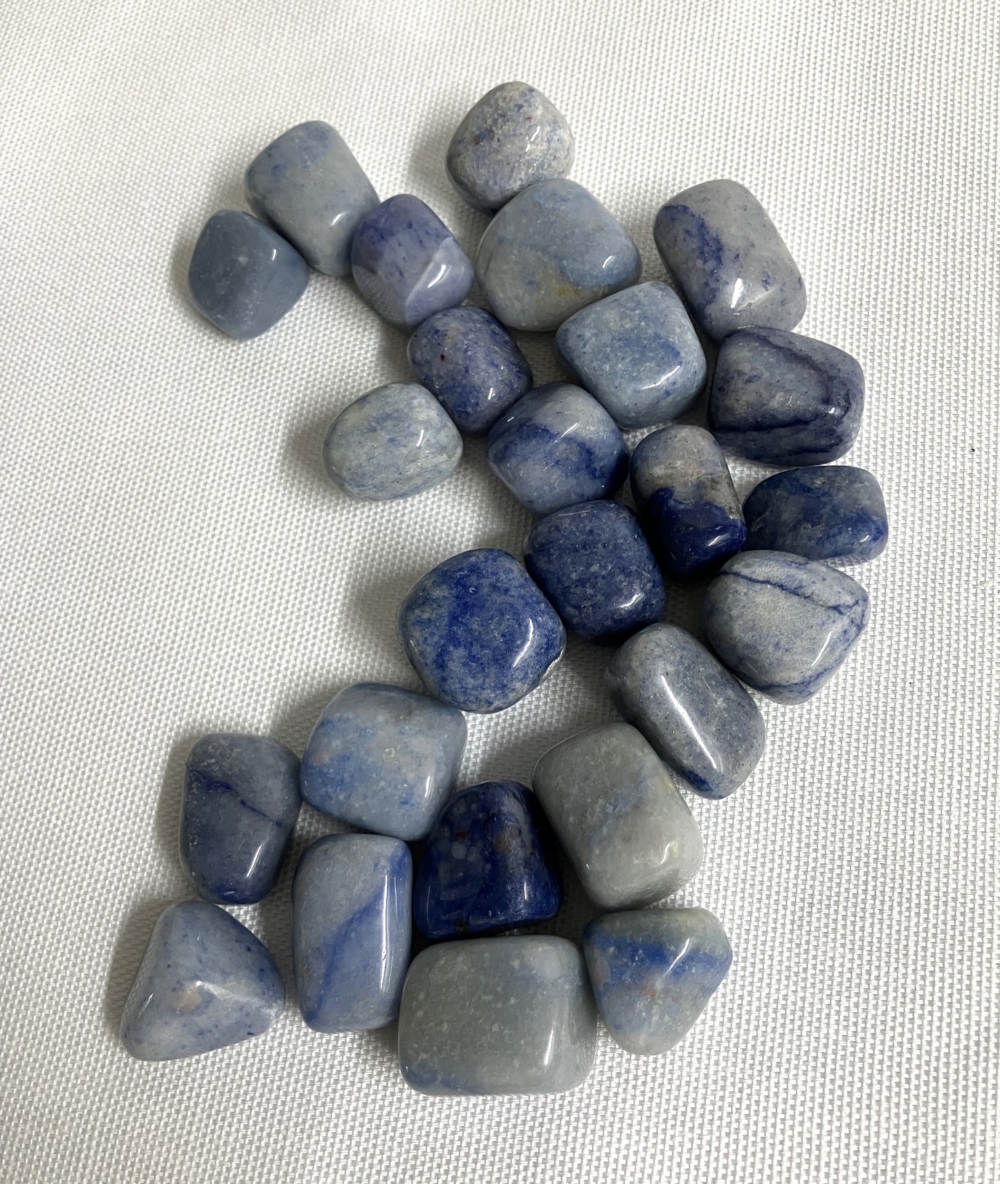 Collection of Dumortierite Crystals showing the assorted veining on a light fabric background