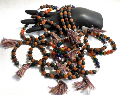Chakra Stone Stretch Bracelet w/ Lava and Rudraksha Seeds with tassels on a black mannequin hand against a white background