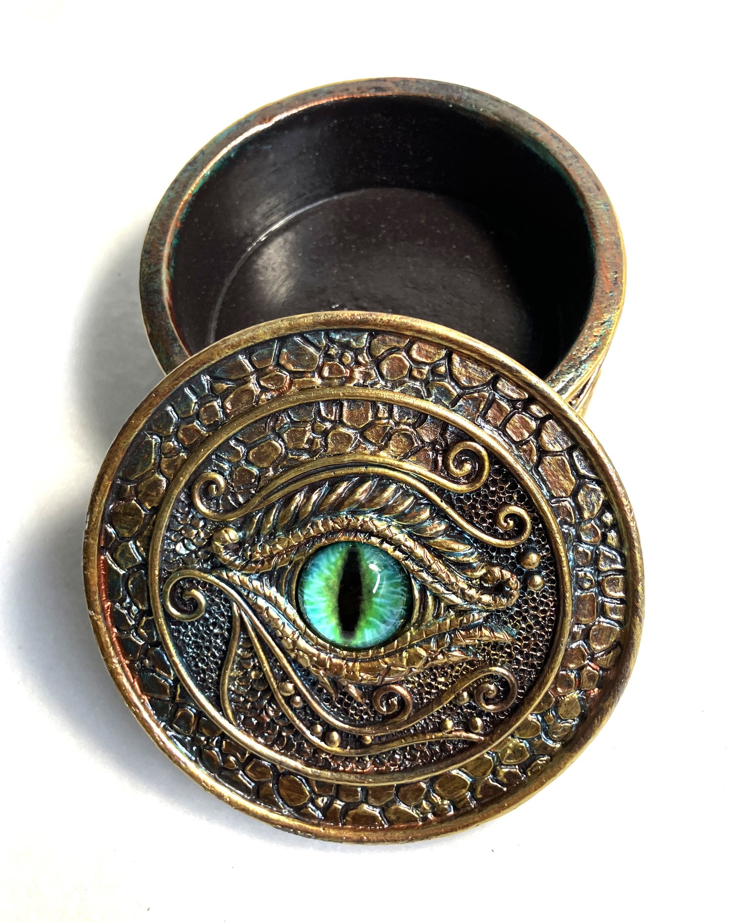 Decorative container with dragon eye design shown on a white background