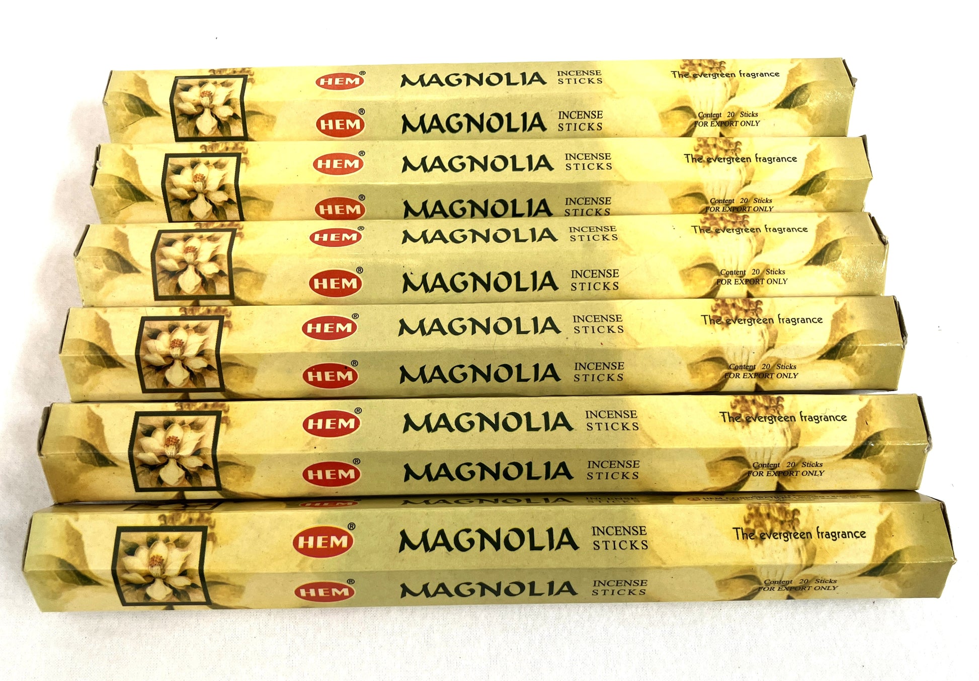 Multiple boxes of HEM Magnolia incense sticks on a white background