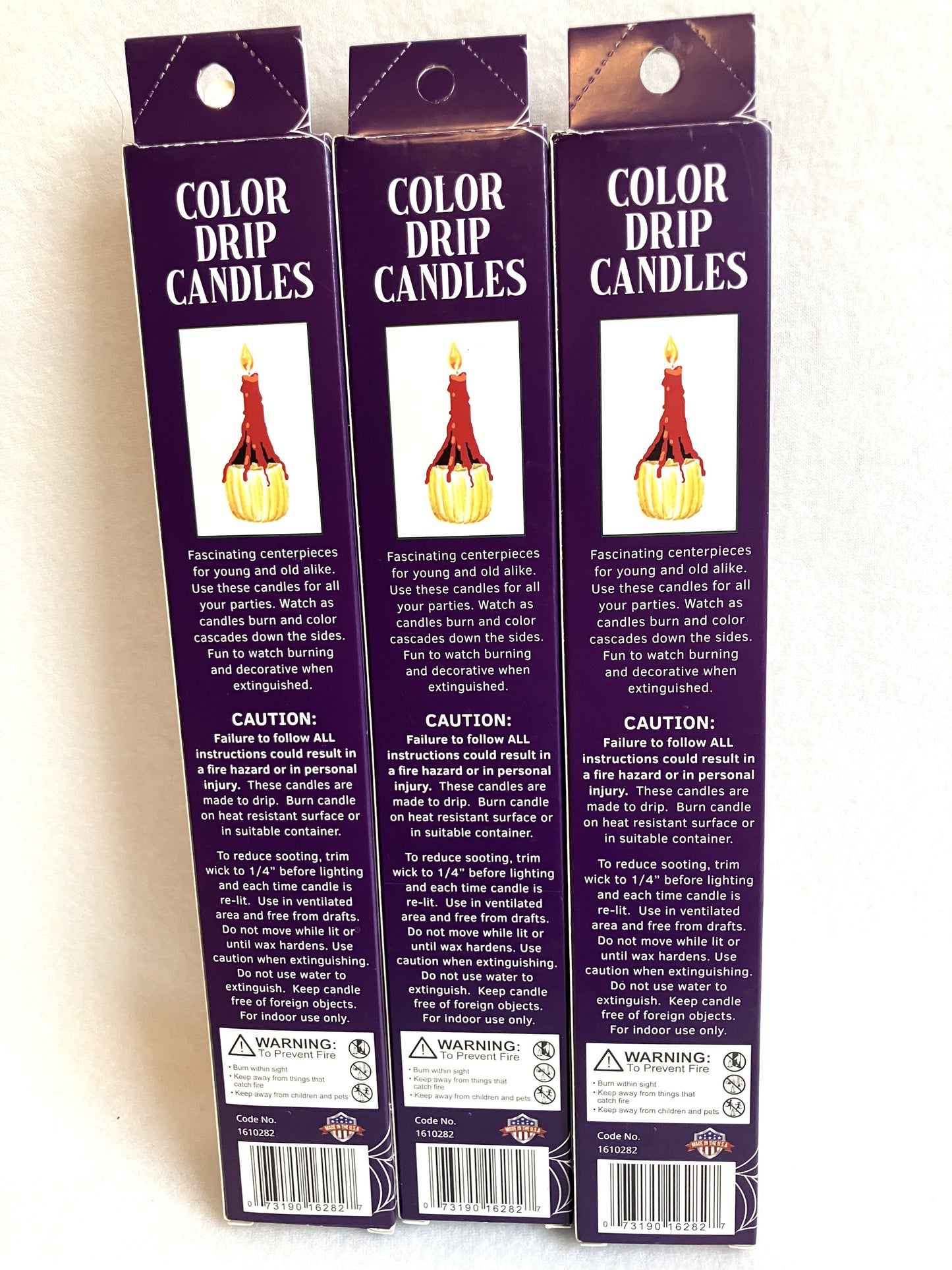 Back of three packages of Color Drip Candles on a white background