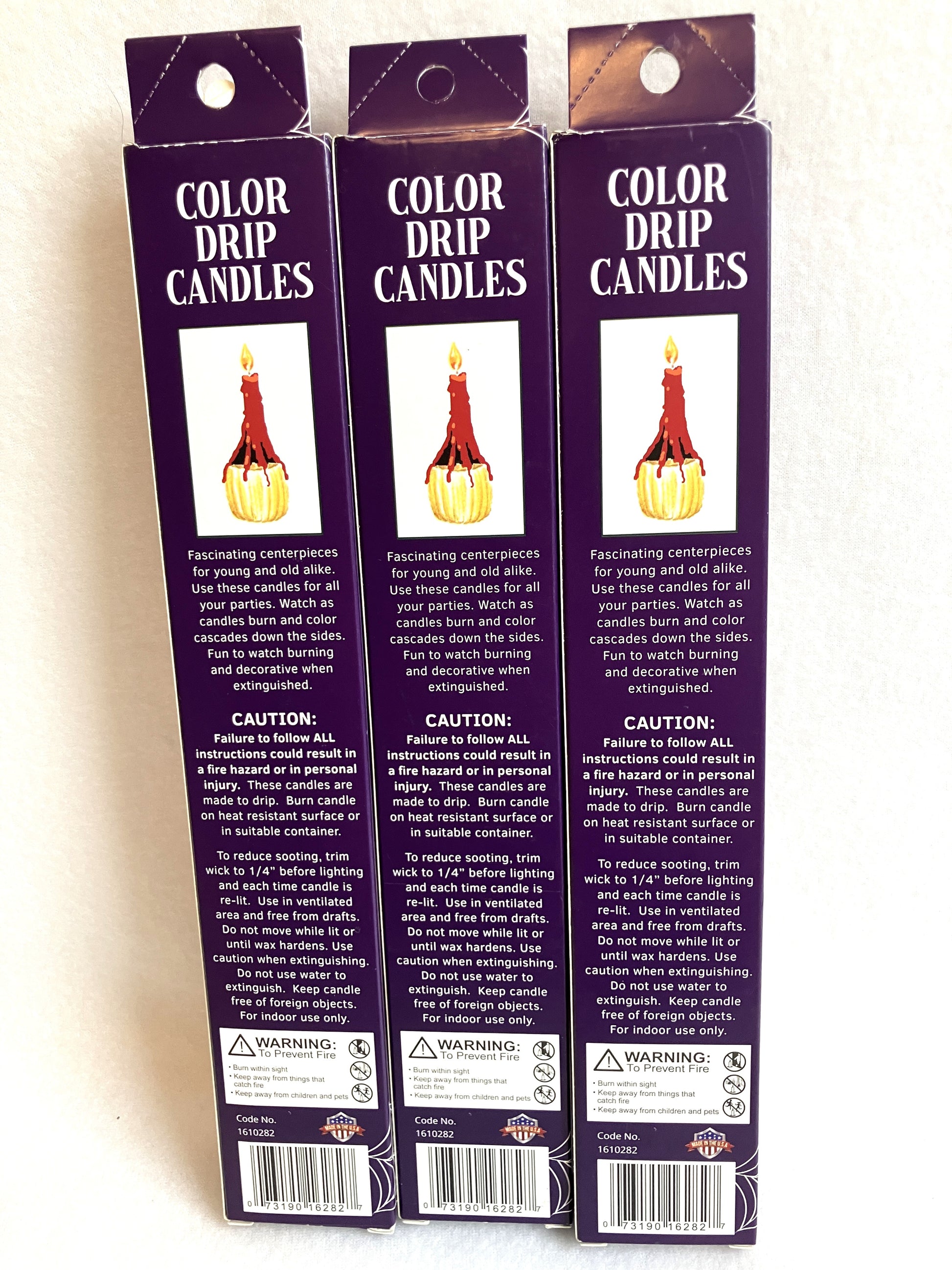 Back of three packages of Color Drip Candles on a white background