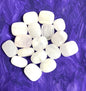 Natural light Pink Calcite Crystals on a purple textured fabric background
