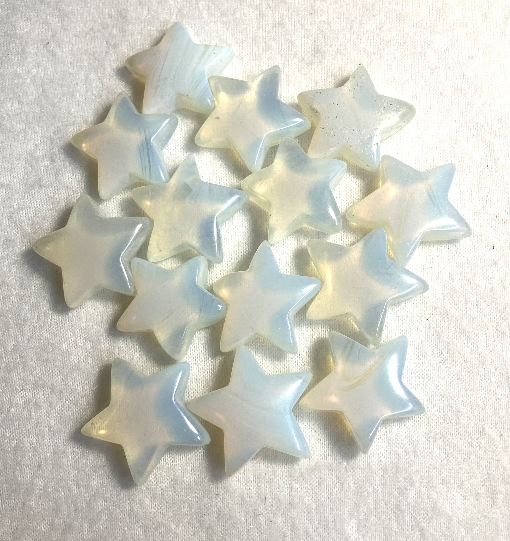 Group of Opalite Stars shown on a cream background showing the shine