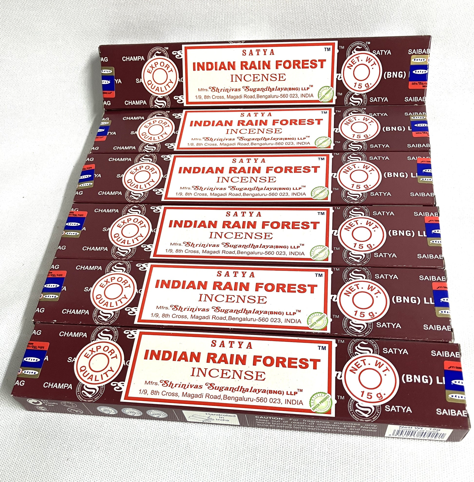 Multiple boxes of Satya Indian Rain Forest Incense stacked on a white background