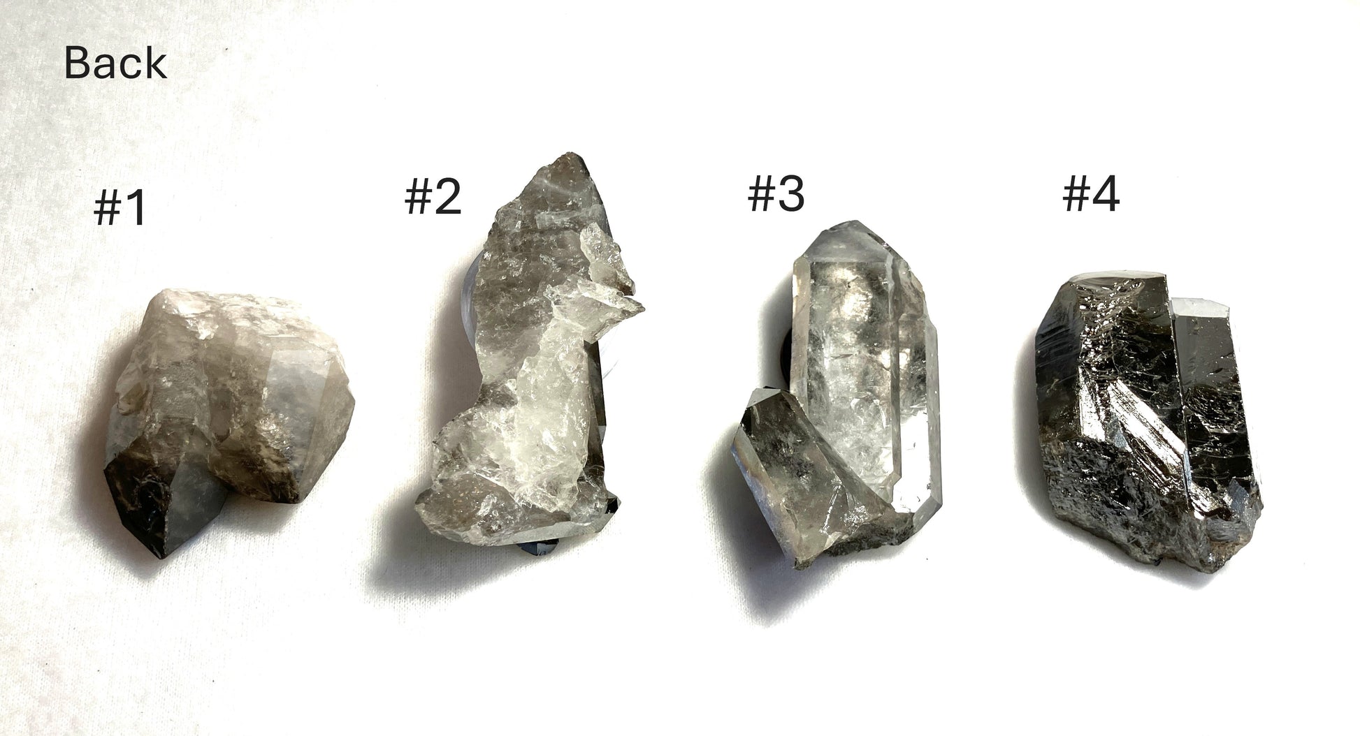 Back of four Titanium Plated Quartz crystal specimens labeled #1 to #4 on a white background