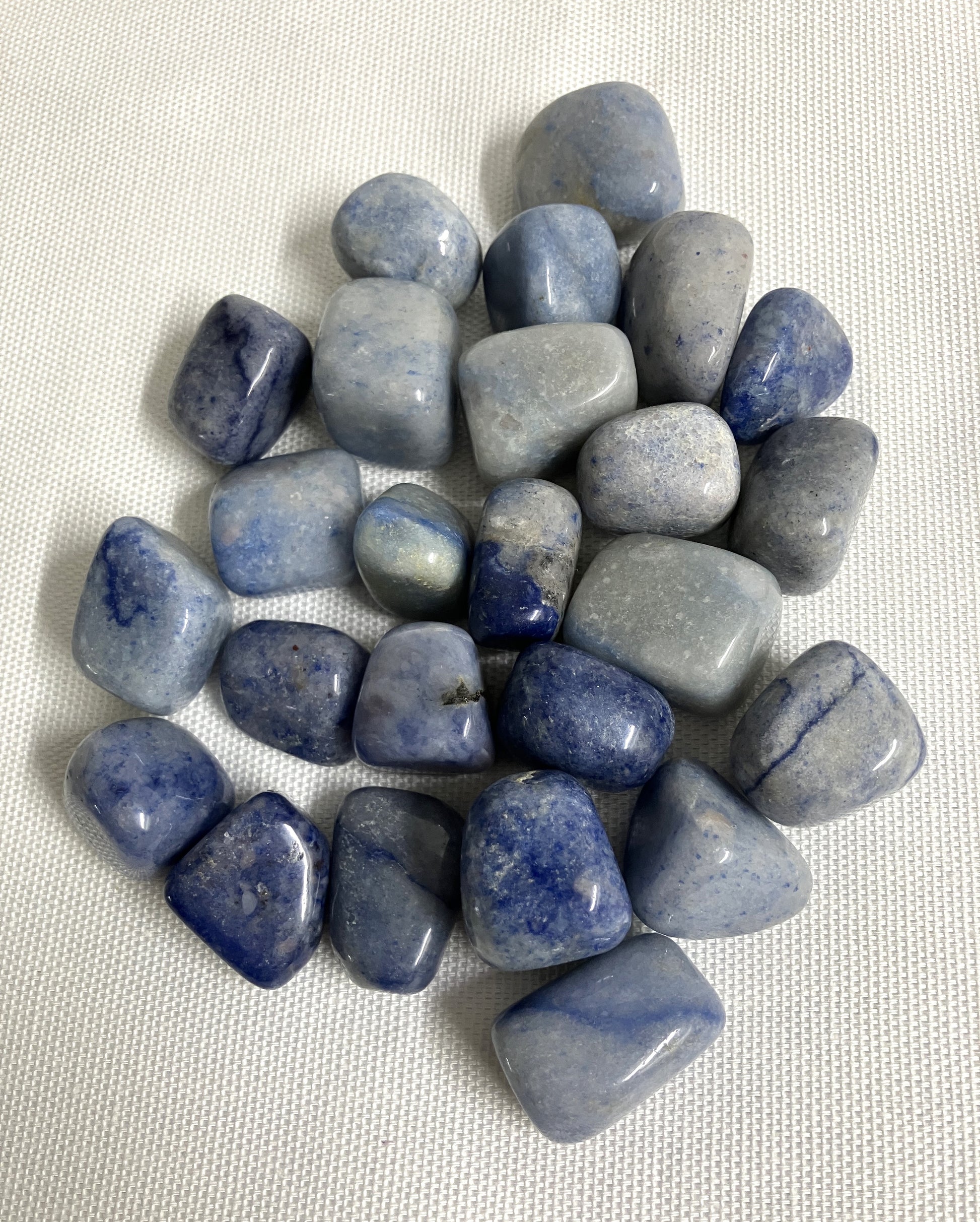 Collection of Dumortierite Crystals on a white fabric background