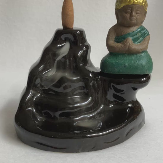 Backflow Buddha incense burner showing the smoke cascading down the front with the buddha statue on the right side