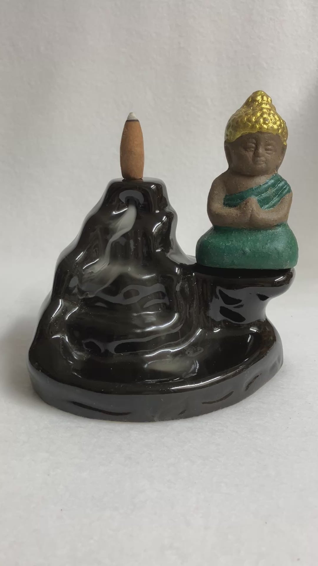 Backflow Buddha incense burner showing the smoke cascading down the front with the buddha statue on the right side