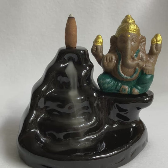 Ganesh Backflow Burner shown with a burning cone and smoke cascading down the front